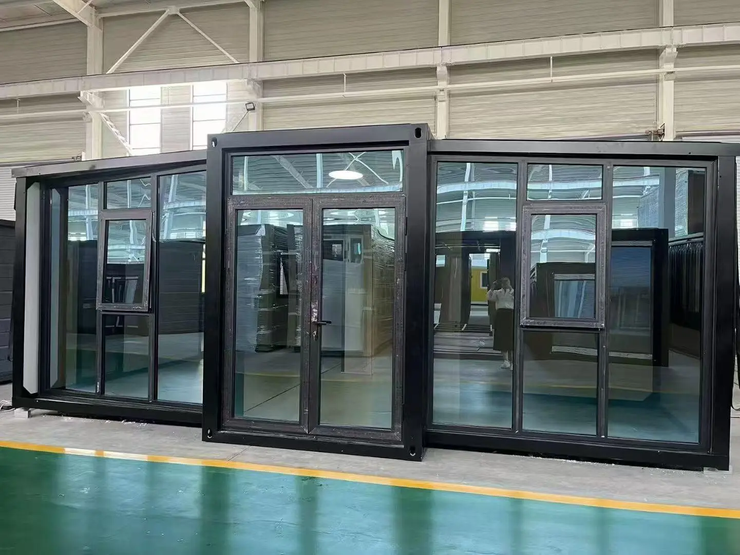 Glazed flat-pack modular unit displayed on a factory floor